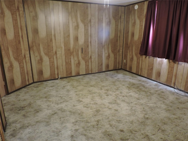 unfurnished room with wood walls and carpet flooring
