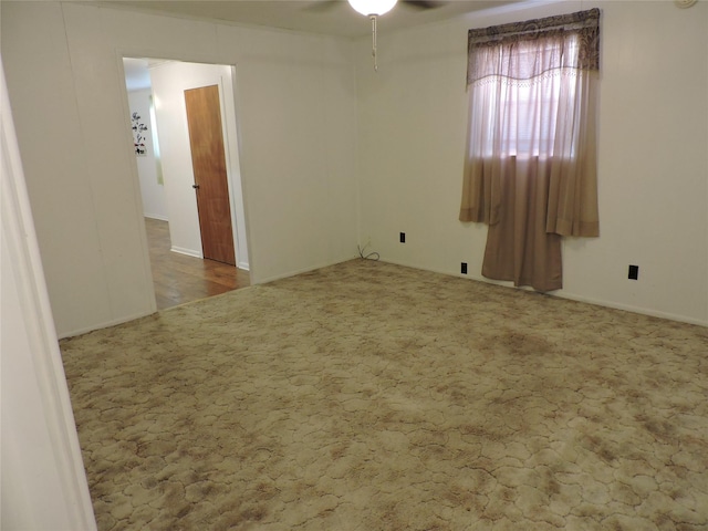 carpeted spare room featuring a ceiling fan