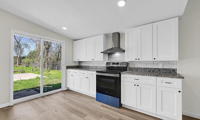 1541 Clark Ave, Waco, TX 76708 - kitchen with vaulted ceiling, white cabinetry, wall chimney exhaust hood, light wood-style flooring, and stainless steel electric range oven