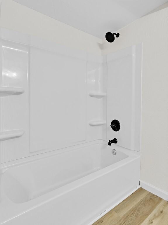 1541 Clark Ave, Waco, TX 76708 - bathroom featuring baseboards, bathtub / shower combination, and wood finished floors