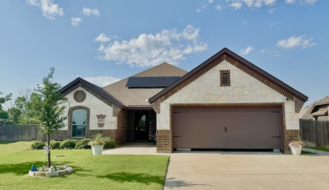 4711 Bering Dr, Sanger, TX 76266 - french provincial home featuring driveway, solar panels, stone siding, an attached garage, and roof with shingles