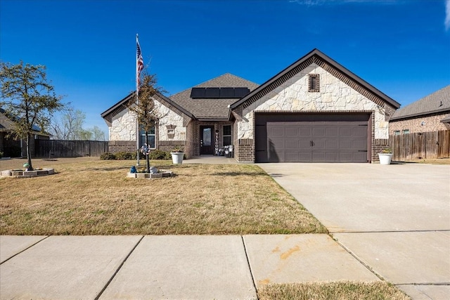 4711 Bering Dr, Sanger, TX 76266 - french country style house featuring stone siding, a garage, solar panels, concrete driveway, and brick siding