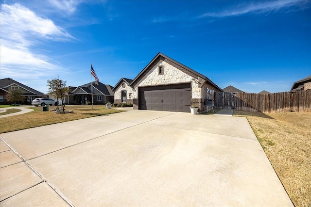 4711 Bering Dr, Sanger, TX 76266 - french provincial home featuring an attached garage, concrete driveway, and stone siding