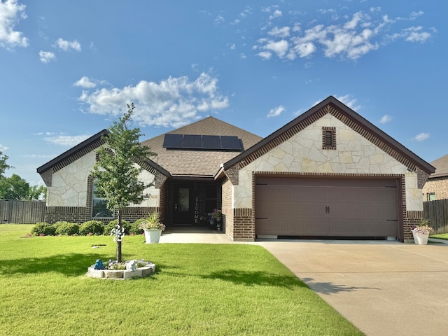 4711 Bering Dr, Sanger, TX 76266 - view of front of property with concrete driveway, brick siding, roof mounted solar panels, a garage, and a shingled roof