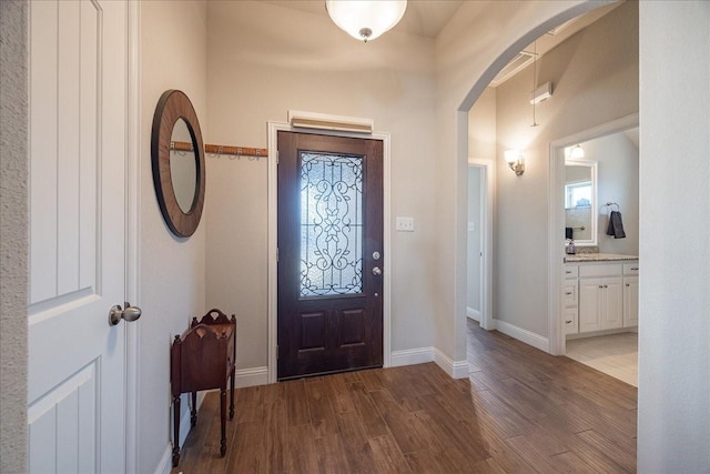 4711 Bering Dr, Sanger, TX 76266 - entrance foyer with arched walkways, dark wood-type flooring, and baseboards
