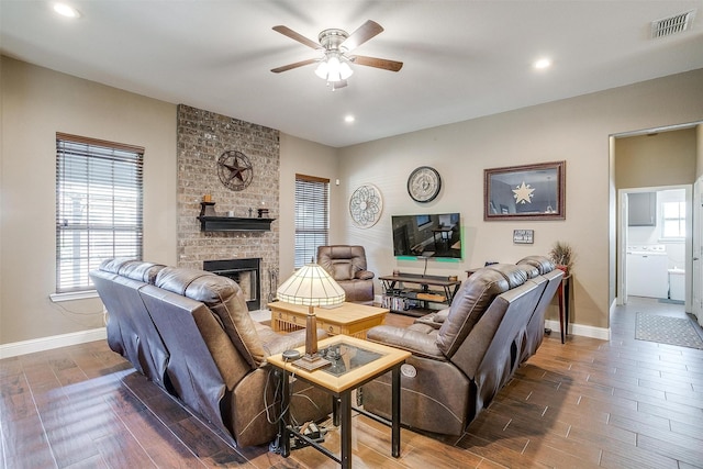 living room featuring wood finished floors, visible vents, a fireplace, and ceiling fan
