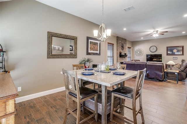 dining space featuring visible vents, baseboards, wood finished floors, recessed lighting, and ceiling fan with notable chandelier