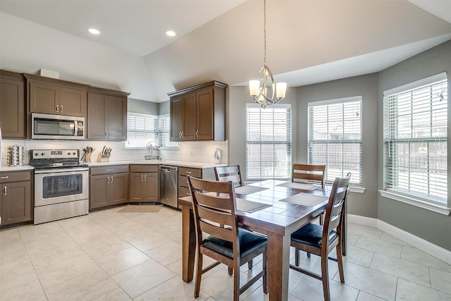 dining room with light tile patterned floors, baseboards, lofted ceiling, and recessed lighting