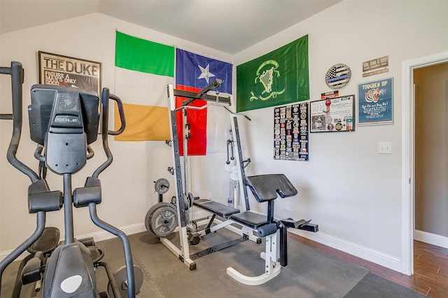 exercise area featuring baseboards, vaulted ceiling, and wood finished floors