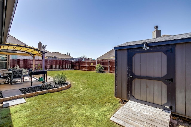 view of yard with a fenced backyard, a patio area, a storage unit, and an outdoor structure