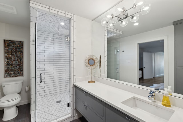 bathroom with vanity, toilet, a shower stall, and wood finished floors