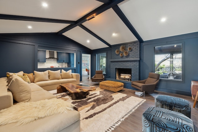 living area featuring lofted ceiling with beams, a fireplace, and wood finished floors