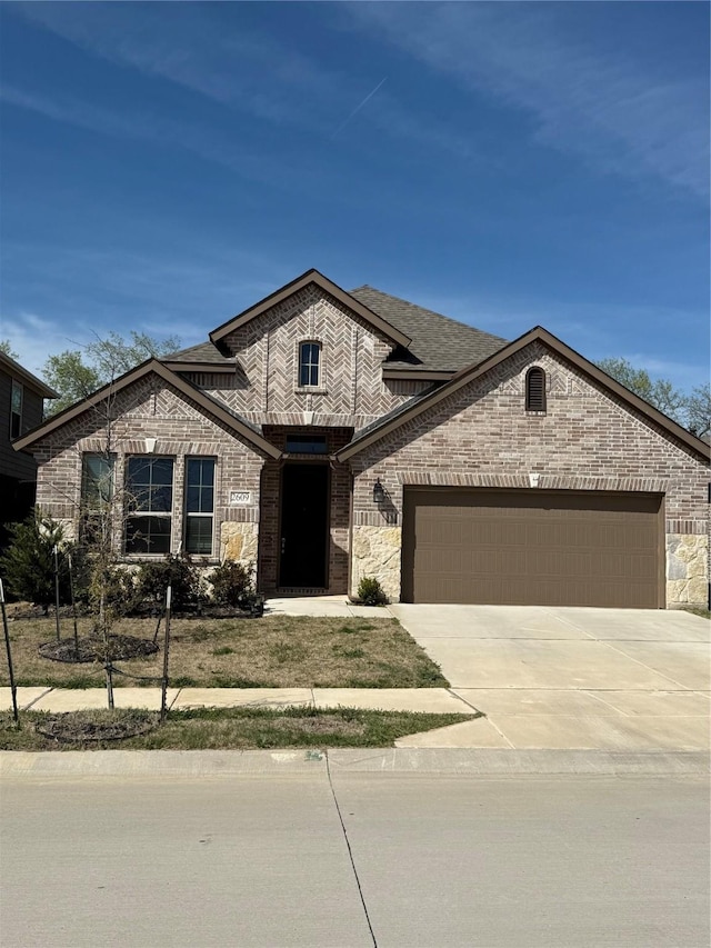 2609 Chevy Chase Dr, Denton, TX 76207 - french country inspired facade with a garage, concrete driveway, stone siding, and roof with shingles