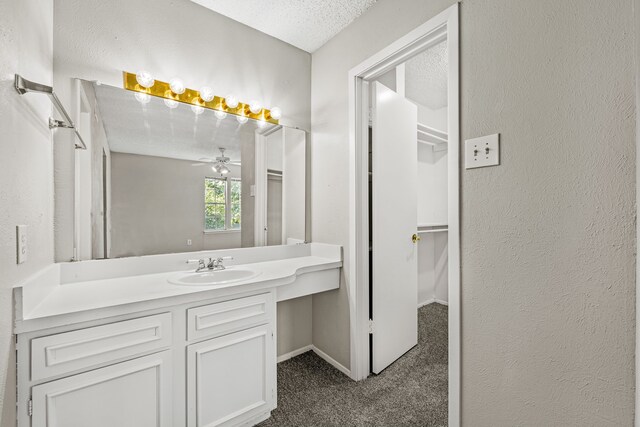 5300 Keller Springs Rd Unit 2044, Dallas, TX 75248 - bathroom with a textured ceiling, vanity, a ceiling fan, a textured wall, and baseboards