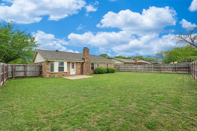 4629 Cripple Creek Rd, Haltom City, TX 76137 - back of property featuring a patio, a fenced backyard, a chimney, brick siding, and a lawn