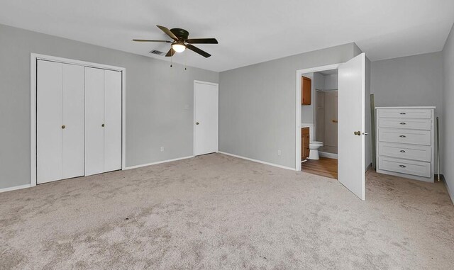 unfurnished bedroom with carpet, visible vents, ensuite bath, a closet, and baseboards