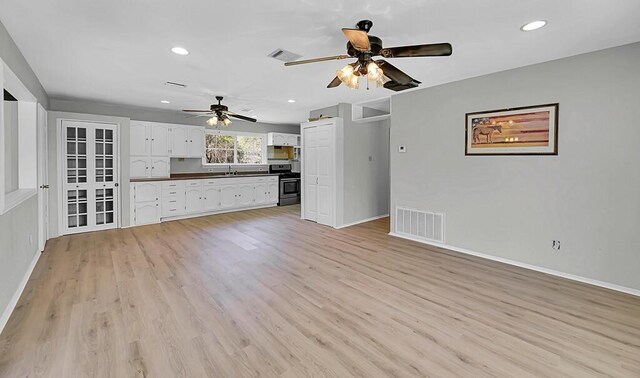 unfurnished living room with visible vents, a ceiling fan, and baseboards