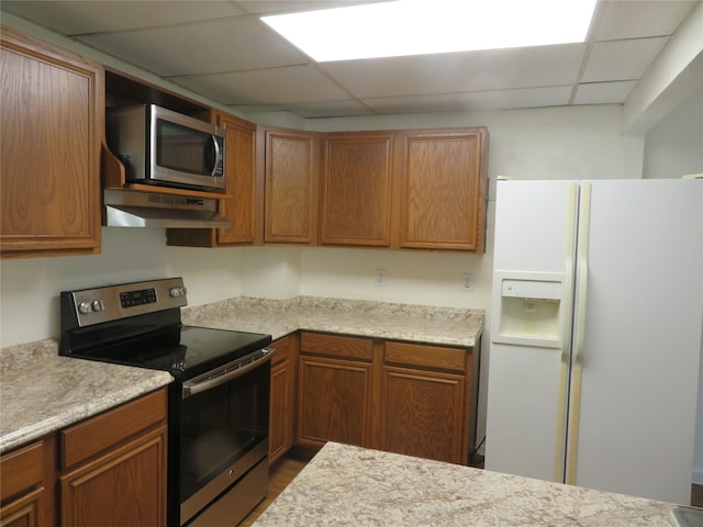 kitchen featuring a paneled ceiling, under cabinet range hood, light countertops, and stainless steel appliances