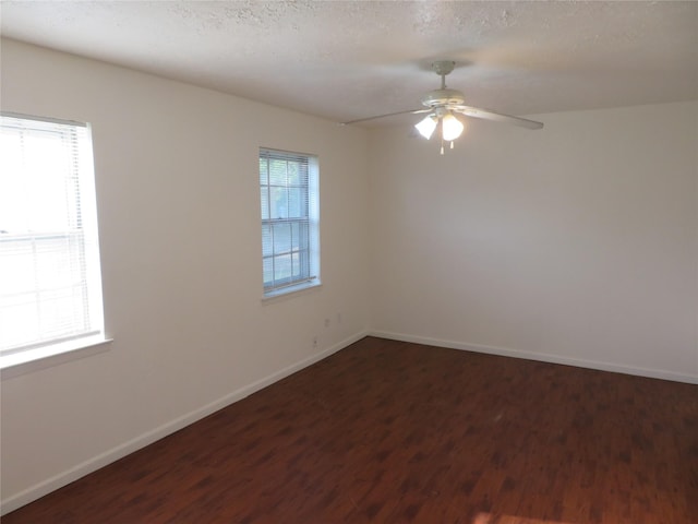 unfurnished room featuring dark wood-type flooring, baseboards, and a ceiling fan