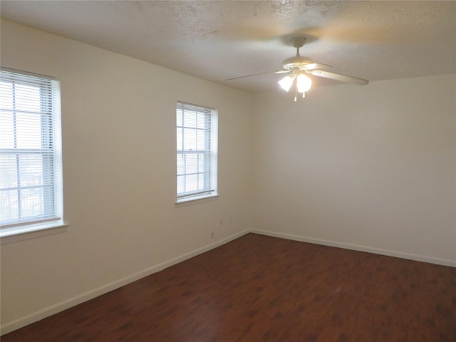 spare room featuring ceiling fan, baseboards, a textured ceiling, and dark wood finished floors