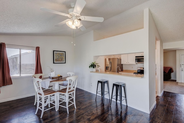 1201 High Valley Dr, Garland, TX 75041 - dining area featuring baseboards, a ceiling fan, a textured ceiling, dark wood-style floors, and vaulted ceiling