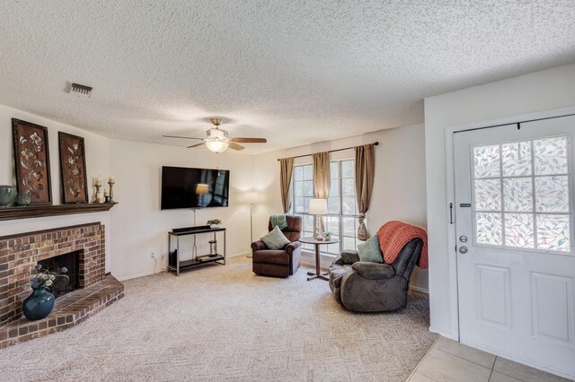 1201 High Valley Dr, Garland, TX 75041 - living room with visible vents, a ceiling fan, carpet, a fireplace, and a textured ceiling