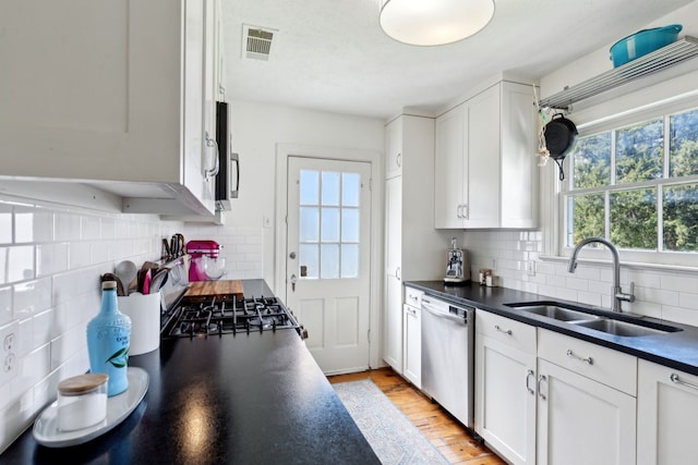 6926 Santa Monica Dr, Dallas, TX 75223 - kitchen with white cabinets, visible vents, dark countertops, a sink, and stainless steel dishwasher