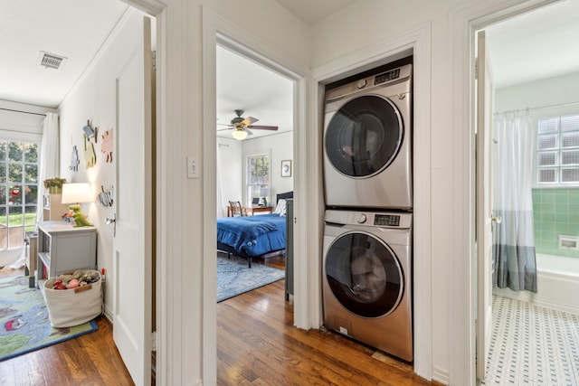 6926 Santa Monica Dr, Dallas, TX 75223 - clothes washing area featuring stacked washer and dryer, wood finished floors, laundry area, visible vents, and ceiling fan