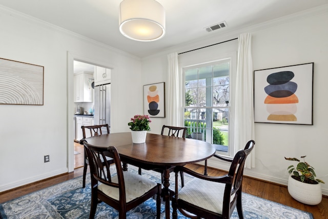 6926 Santa Monica Dr, Dallas, TX 75223 - dining space featuring baseboards, dark wood-style flooring, visible vents, and crown molding