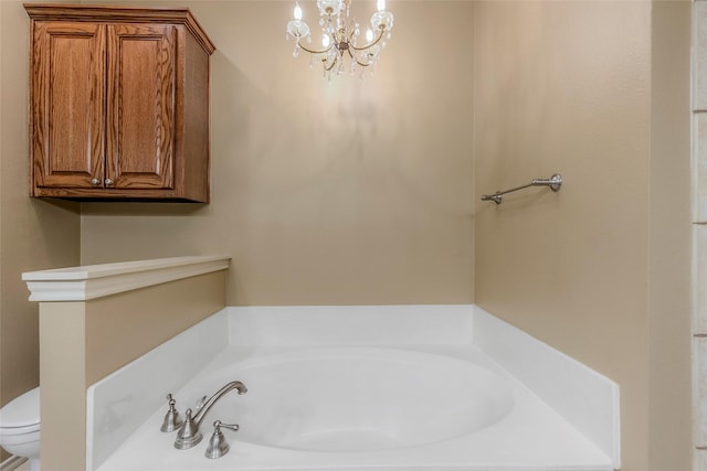 bathroom with toilet, a bath, and a chandelier