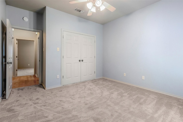 unfurnished bedroom with ceiling fan, a closet, light colored carpet, and visible vents