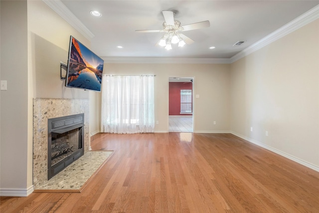 unfurnished living room with visible vents, light wood finished floors, baseboards, ornamental molding, and a ceiling fan