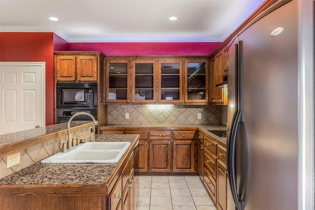 kitchen featuring light tile patterned flooring, crown molding, a sink, black appliances, and brown cabinetry