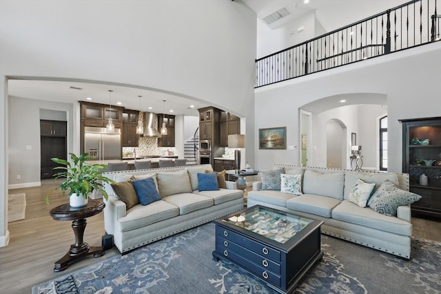 3905 Dashiell Dr, Flower Mound, TX 75022 - living area featuring a high ceiling, wood finished floors, arched walkways, and baseboards