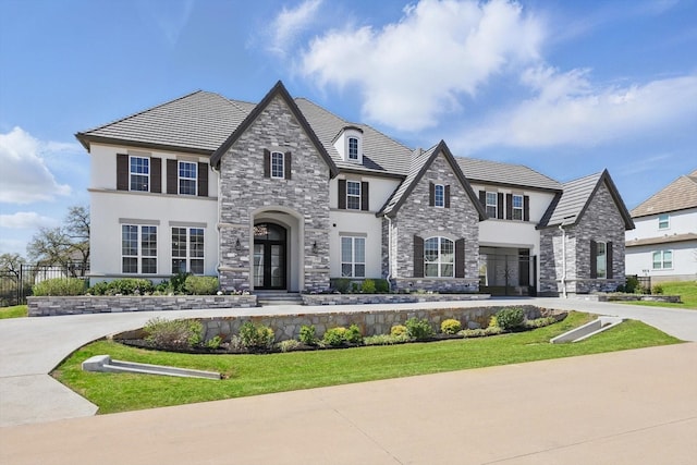 3905 Dashiell Dr, Flower Mound, TX 75022 - french country style house with stucco siding, stone siding, french doors, and fence