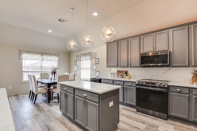 kitchen with a healthy amount of sunlight, gray cabinets, light countertops, and stainless steel appliances
