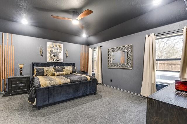 bedroom with a ceiling fan, multiple windows, and carpet