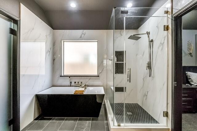 full bathroom featuring a freestanding bath and a marble finish shower