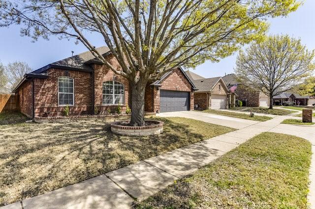 view of front of home featuring brick siding, driveway, and a garage