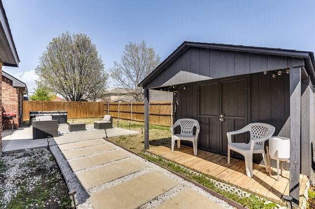 view of yard with a fenced backyard, a patio, an outdoor structure, and a storage shed