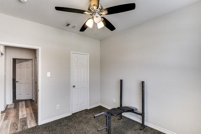 exercise room with carpet flooring, baseboards, ceiling fan, and visible vents