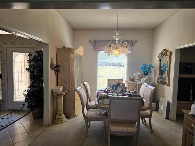 carpeted dining area with a chandelier and a textured ceiling