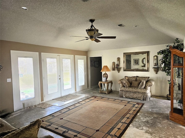 living area featuring vaulted ceiling, french doors, a textured ceiling, visible vents, and ceiling fan