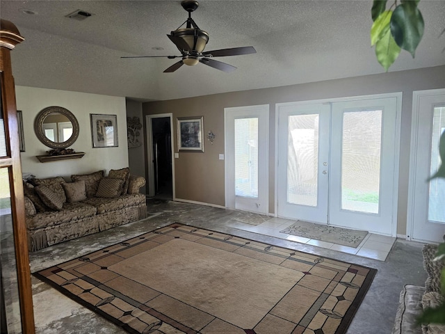unfurnished living room featuring french doors, baseboards, a textured ceiling, visible vents, and a ceiling fan
