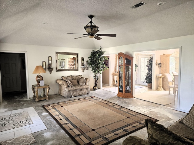 living room with a textured ceiling, visible vents, and a ceiling fan