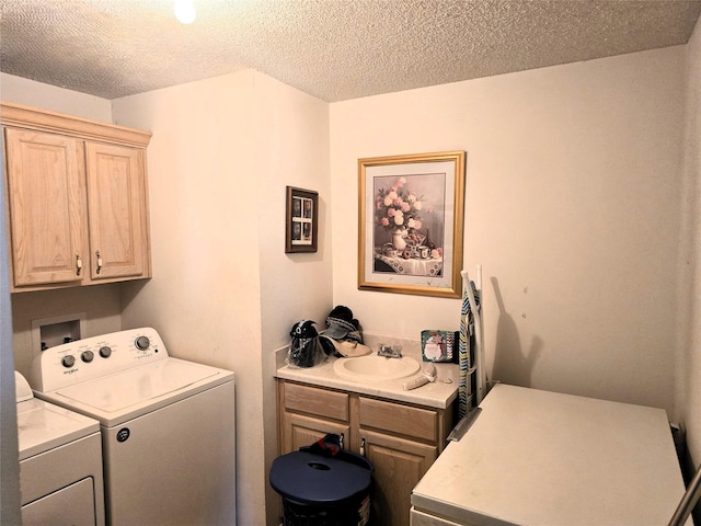 clothes washing area featuring washing machine and clothes dryer, cabinet space, a textured ceiling, and a sink