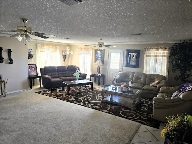 living area with plenty of natural light, a textured ceiling, visible vents, and a ceiling fan