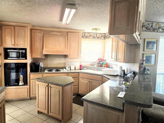 kitchen with a sink, a peninsula, stovetop, built in microwave, and oven