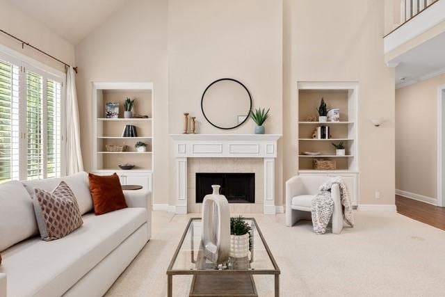 2034 Oak Glen Dr, Mcgregor, TX 76657 - living room with high vaulted ceiling, built in features, a tiled fireplace, baseboards, and light carpet