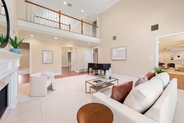 2034 Oak Glen Dr, Mcgregor, TX 76657 - living room with a towering ceiling, arched walkways, ceiling fan, a high end fireplace, and baseboards